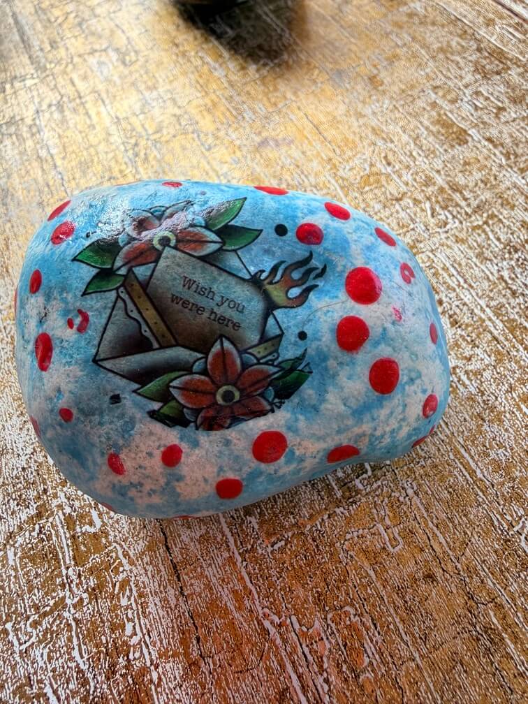Painted stone No. 5, decorated as: Wish You Were Here envelope