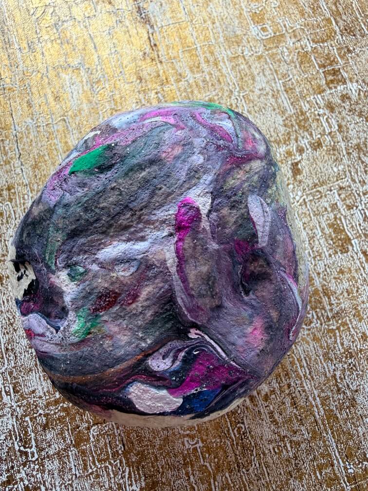 Painted stone No. 9, decorated as: Swirly black, white, pink, green dots