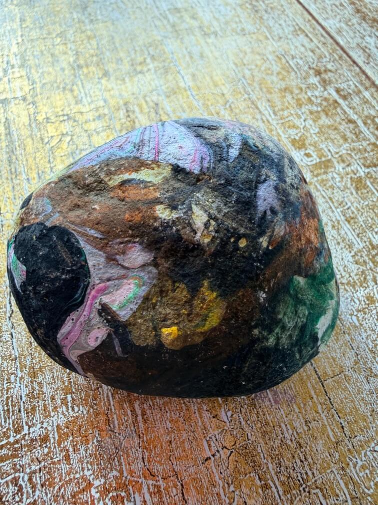 Painted stone No. 12, decorated as: Black, whitey pink swirls, yellow splat
