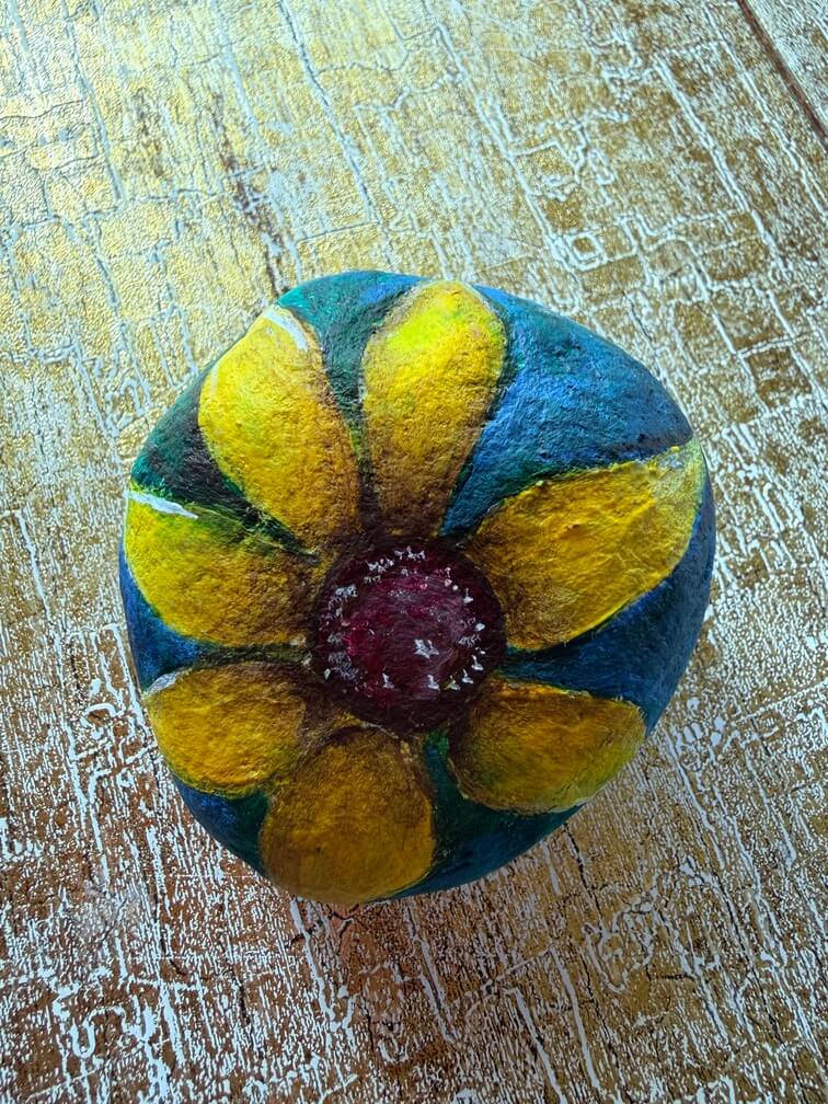 Painted stone No. 16, decorated as: Yellow flower on turquoise