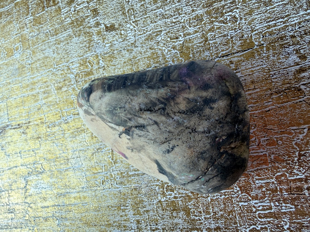 Painted stone No. 18, decorated as: Half painted black, small pink dot