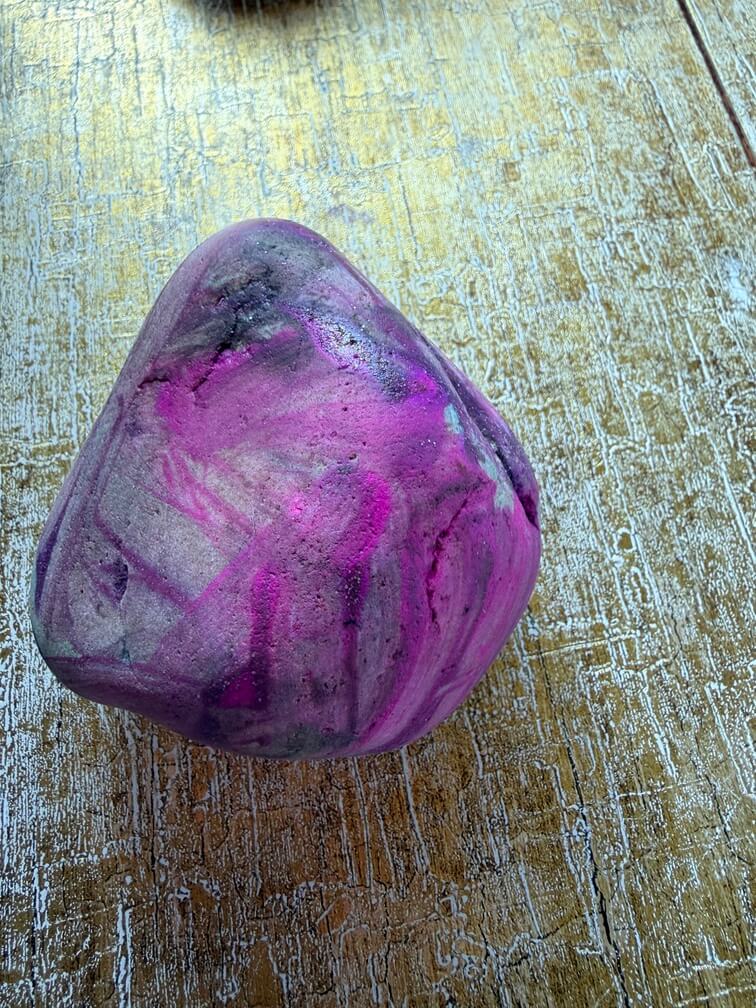 Painted stone No. 34, decorated as: Pryamid pink finger paint with purple sparkle