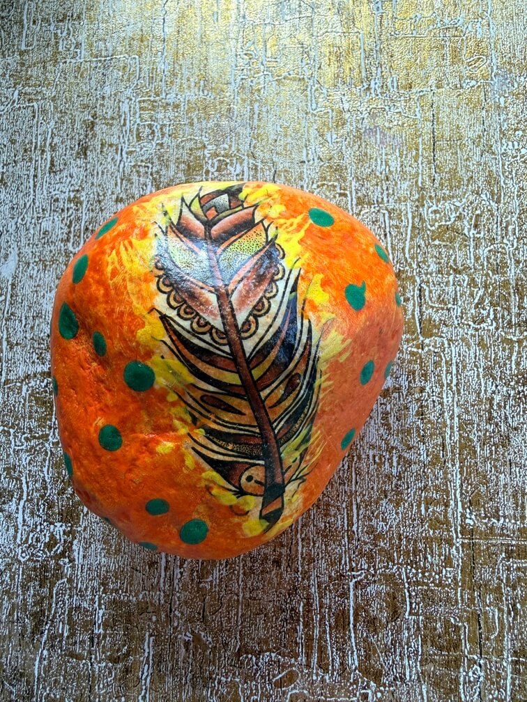 Painted stone No. 43, decorated as: Orange green dot feather