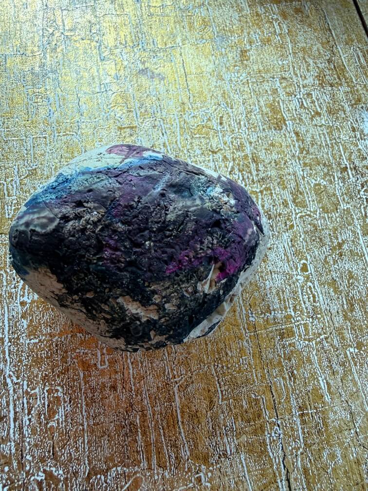 Painted stone No. 54, decorated as: Black half painted, blue line, pink splodge